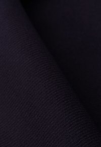 Tessuto scuro a trama, caratterizzato da un motivo a intreccio fitto. Il colore appare di un blu navy profondo o nero, mostrando una superficie liscia e opaca.