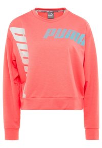 Korálově růžová mikina vyrobená z měkké látky, má kulatý výstřih a dlouhé rukávy. Logo "PUMA" v světle modré a bílé grafice podél strany.