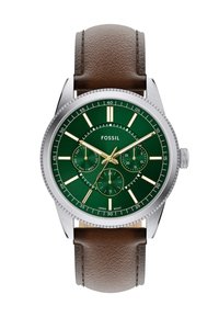 Montre en acier inoxydable avec un cadran texturé vert, des aiguilles dorées et un bracelet en cuir brun. Elle dispose de trois sous-cadrans et de marqueurs d'heure blancs.