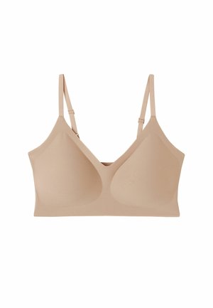 Nude wireless bra with smooth, stretchy fabric, V-shaped neckline, adjustable straps, and lightly contoured cups for support.