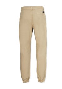 Helle beigefarbene Hose aus Baumwolle mit tailliertem Schnitt und elastischen Bündchen. Verfügt über eine Gesäßtasche und ein Markenlabel am Bund.