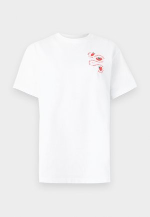 Λευκό κοντομάνικο μπλουζάκι με μικρές κόκκινες εικόνες ντομάτας και κυκλικό κείμενο στην αριστερή επάνω πλευρά του στήθους.