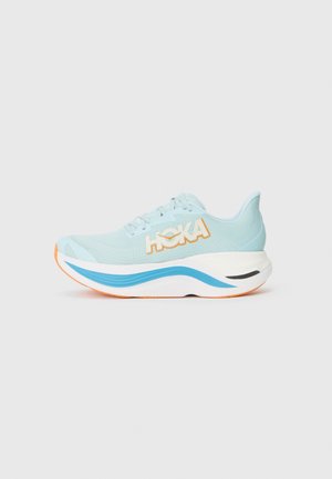 Chaussure de course bleu clair avec une semelle blanche épaisse, un détail vague bleu, une semelle extérieure orange, et un logo blanc avec un contour orange sur le côté.