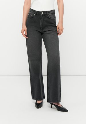 Høyt liv, vide denimjeans i mørkegrått med frontlommer og glidelås foran. Pare med svarte spisse hæler.