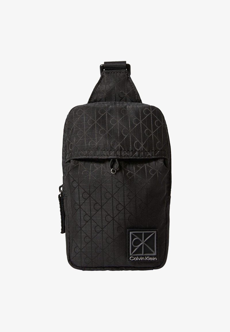 Μαύρη τσάντα Calvin Klein χιαστί με μοτίβο λογότυπου CK σε όλη την επιφάνεια, εμπρός τσέπη με φερμουάρ και ρυθμιζόμενο λουρί.
