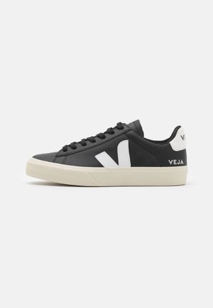 Sneaker in pelle nera con accento di logo bianco, upper texturizzato, punta rotonda e suola piatta in gomma. Presenta lacci neri e dettagli del marchio a contrasto.