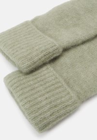 Sosete tricotate de culoare verde deschis, cu manșete elastice, având o textură moale și pufoasă. Marginile manșetelor sunt finisate cu atenție pentru durabilitate.