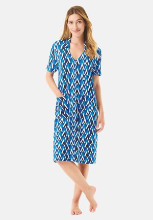 Vestido azul de manga corta con un patrón en zigzag en blanco y negro, que presenta un cierre con botones en la parte delantera y dos bolsillos laterales. Textura de tela suave.