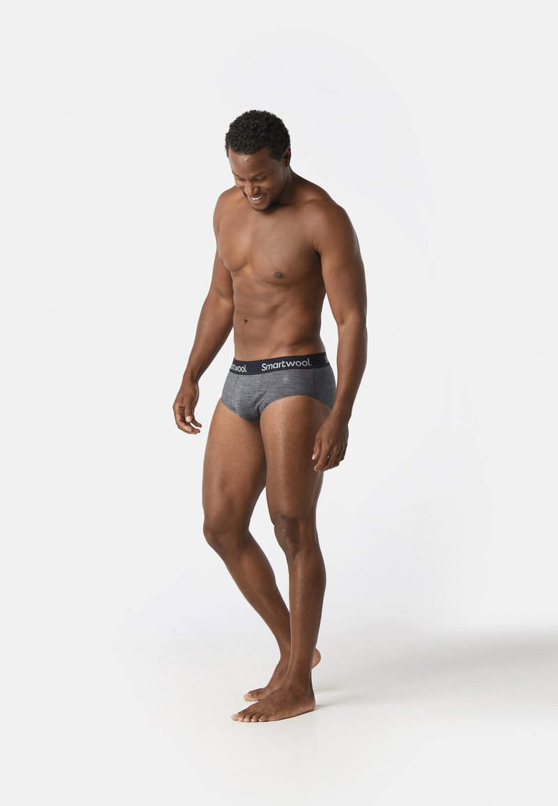 Culotte grise avec une ceinture noire comportant le logo "Smartwool", design ajusté et texture lisse.