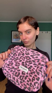 Roze etui met luipaardprint en gewatteerde textuur, met een wit label waarop "lollys laundry" staat. Het etui heeft een rechthoekige vorm en een gladde afwerking.