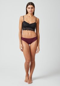 Zwarte kant bralette met dunne bandjes, voorzien van een scalloped rand. Bordeau-kleurige onderbroek met kantafwerking, low-rise stijl. Soepele stoftextuur.