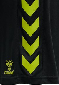 Zwarte sportshorts met een geel chevronpatroon aan de zijkant en een logo. De stof is glad en rekbaar, geschikt voor actieve kleding.