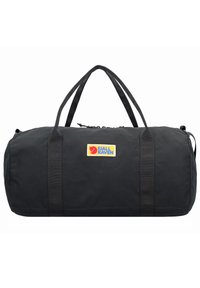 Bolsa de deporte negra hecha de material duradero, con dos asas y cierre de cremallera. Acentuada con un parche del logotipo de Fjällräven.