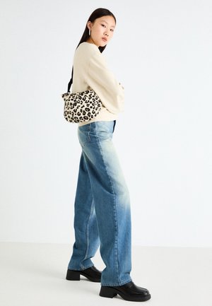 Biała bluza, średnio niebieskie dżinsy z szerokimi nogawkami, czarne botki na obcasie i beżowa torebka w leopardzi wzór. Gładka tekstura i casualowy design.