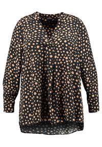 Blusa nera con grandi pois beige, scollatura a V, maniche lunghe e vestibilità morbida. Il tessuto appare liscio con una leggera lucentezza.