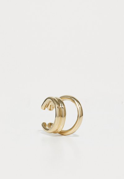 Guldtonede metalørkæder med en glat, blank overflade. Den ene har tre parallelle bånd; den anden har et enkelt, cirkulært design.
