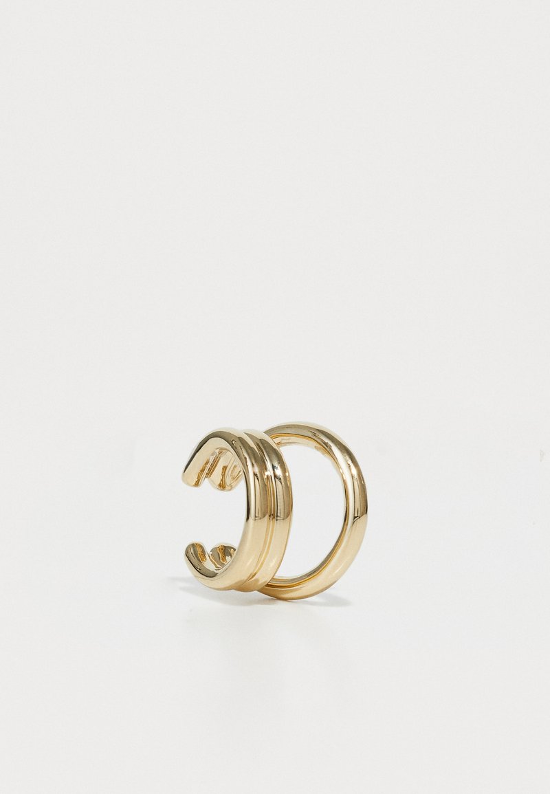 Cuff per orecchie in metallo tono oro con una finitura liscia e lucida. Uno presenta tre bande parallele; l'altro ha un design circolare semplice.