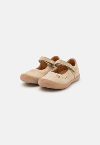 Zapatos Mary Jane de ante beige con una correa, punta redonda y detalles perforados. Las suelas de goma y los acentos cosidos mejoran la durabilidad.