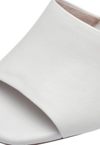 Hvide læder open-toe slide sandaler med en glat tekstur, bred overdel og minimalistsk design. Ingen synlig hardware eller accenter.
