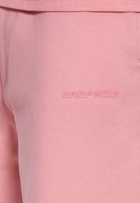 Sweat-shirt rose doux avec logo en relief "DROPSIZE" centré sur la poitrine.