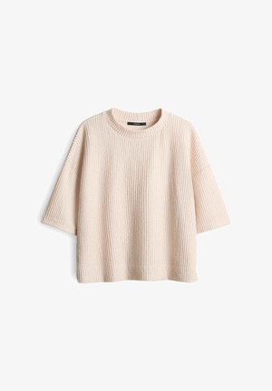 Lichtbeige oversized trui gemaakt van getextureerde breigoed. Bevat korte mouwen, een ronde halslijn en ribbel details overal.