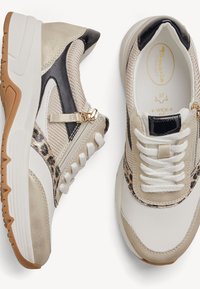 Chunky beige and white sneakers with black and leopard print accents, white laces, side zipper, and brown rubber soles, shown from top and side views.