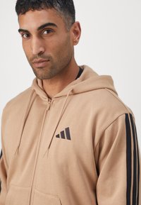 adidas Sportswear Camisola com fecho - warm sandstone/black