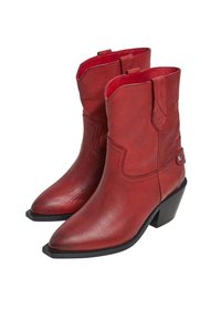 Botas de vaquero rojas de cuero con punta afilada, costuras decorativas y un tacón negro de altura media. El interior presenta un forro rojo en contraste.