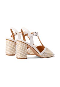 Sandali slingback bianchi in pelle con tacco a blocco intrecciato beige e design a T, dotati di una fibbia in argento e punta aperta.
