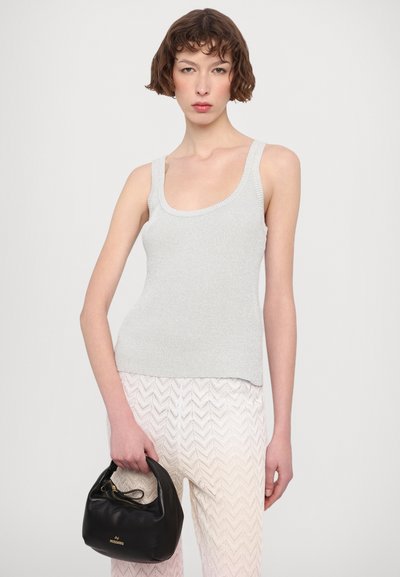 Top de tirantes anchos de canalé gris claro, combinado con pantalones de punto que presentan un patrón en forma de chevrón en suaves tonos pastel. Se incluye un bolso negro.