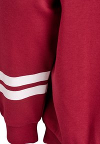 Mørkerød sweatshirt med hvide striber på ærmerne. Lavet af bomuld, den har en blød tekstur og ribbede manchetter for en tætsiddende pasform.