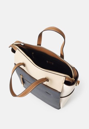 Vue de dessus d’un sac à main bicolore beige et gris avec des anses marron, une fermeture éclair ouverte, et une poche avant zippée avec un tirette en cuir.