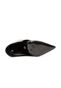 Pump nera in pelle con punta affusolata e finitura liscia. Presenta una silhouette elegante e una suola testurizzata, evidenziando un design minimalista.