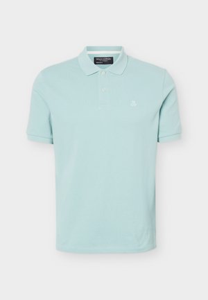 Lyseblå kortermet poloshirt med to knapper, krage og liten "M OP"-logo på venstre bryst.