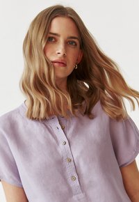 Lavendel shirt met korte mouwen van zachte stof, met een knoopsluiting aan de voorkant, een ronde halslijn en minimale stikdetails.