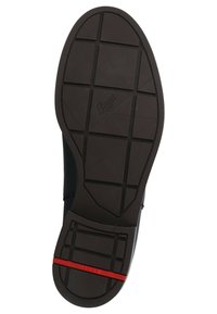 Suela de zapato de goma negra con agarre texturizado, que presenta una línea de acento roja y un patrón de cuadrícula para tracción. Nombre de la marca "Leoya" grabado.