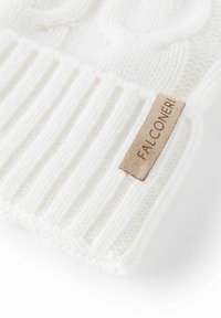 Witte gebreide beanie met een geribbelde textuur. Beschikt over een horizontale band en een opvallend lichtbruin leren label met de tekst "FALCONERI."