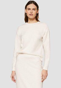 Hellbeige Sweatshirt mit langen Ärmeln, aus weichem Stoff, mit Rundhalsausschnitt und lockerer Passform, kombiniert mit einem passenden, figurbetonten Rock.