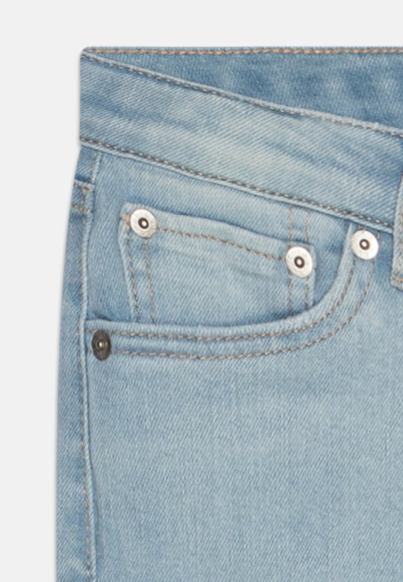 Jean en denim bleu clair avec un look légèrement délavé, présentant une poche avant, des accessoires en métal et des coutures contrastantes en beige.