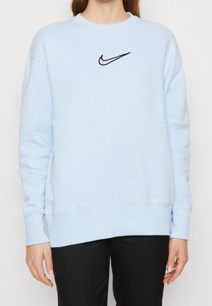 Jasnoniebieska bluz sweatshirt wykonana z mieszanki bawełny, z czarnym logo Nike na piersi, prążkowanymi mankietami oraz luźnym krojem.
