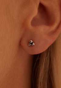 Boucles d'oreilles en argent en trio, présentant un design sphérique poli. Idéales pour un usage quotidien, mettant en valeur le lobe de l'oreille.