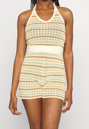 Ensemble top halter et shorts en tricot, avec des rayures dans des teintes de jaune clair, vert et marron, présentant un bord festonné et une texture à mailles ouvertes.