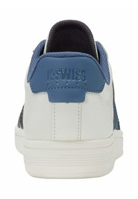 Baskets K-Swiss avec une tige en cuir blanc, un contrefort en cuir bleu, et des accents texturés en bleu marine. Présentent le logo sur le talon et une semelle striée.