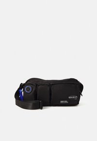 Fekete deréktáska három cipzáras rekesszel, állítható pánttal, kék karabinerrel és bal oldalon kör alakú kombinált zárral.