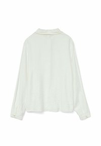 Blusa bianca a maniche lunghe con texture, colletto e polsini con bottoni. Presenta una vestibilità ampia e un motivo leggermente stropicciato.