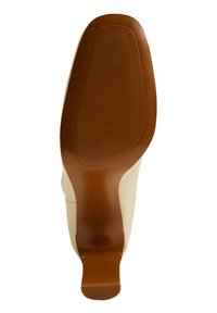 Semelle en caoutchouc marron d'une chaussure à talons hauts, avec un motif de grip texturé pour l'adhérence et un dessus lisse et pâle.