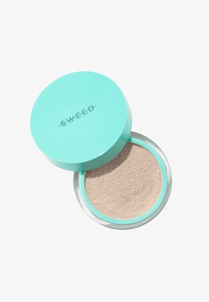 Polvere libera in un contenitore trasparente con un coperchio verde menta. La polvere è di un colore beige chiaro, con una texture liscia e fine.