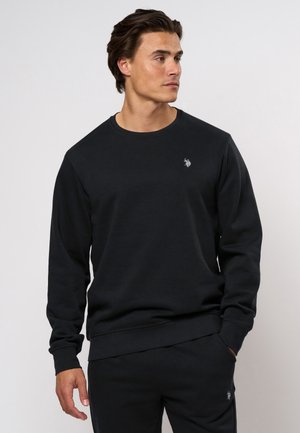 Zwarte katoenen sweatshirt met lange mouwen, ronde hals en geribbelde manchetten. Heeft een klein geborduurd logo op de borst. Soepele textuur.
