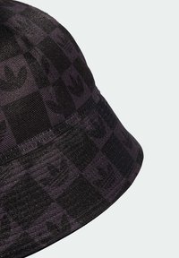 Chapeau seau noir avec un motif à carreaux et un design de logo tonal, fabriqué à partir d'un tissu texturé qui reflète subtilement la lumière.