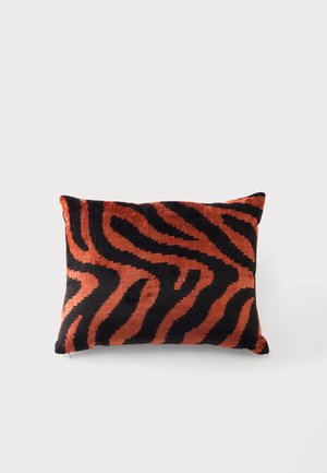 Coussin rectangulaire à texture douce avec des rayures de zèbre noires et orange foncé sur un fond clair uni.